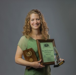 Kosmatka holds her Hall of Fame plaque, North Central Conference championship trophy, and her second-team Division II all-American trophy. 