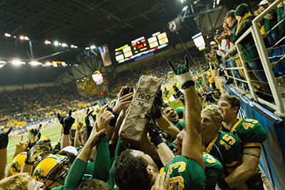 The NDSU football team hoist the Dakota Marker Trophy after defeating South Dakota State