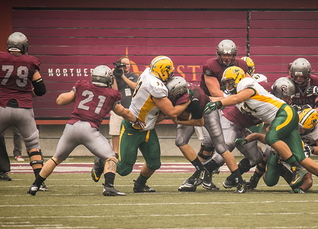 NDSU Bison defensive nose guard Nate Tanguay tackles the Montana running back behind the line of scrimmage
