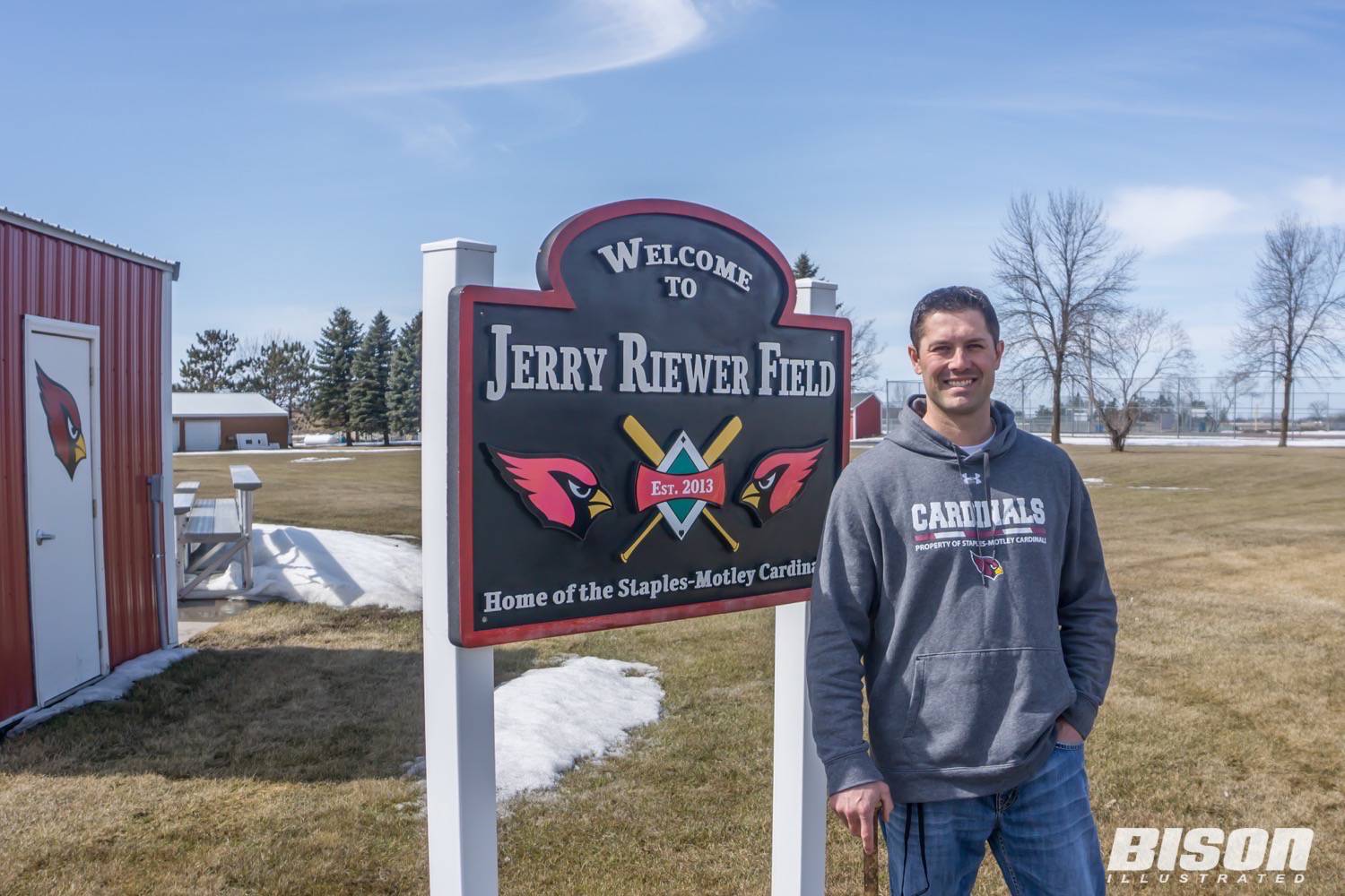 Jeremiah Piepkorn poses in front of Jerry Riewer Field sign
